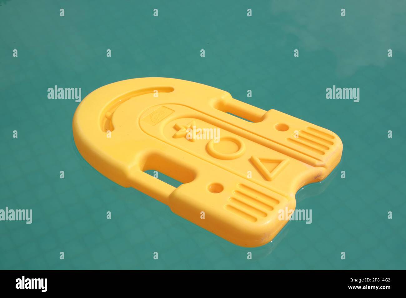 Nuoto in plastica kick board galleggiante nella rinfrescante piscina blu Foto Stock