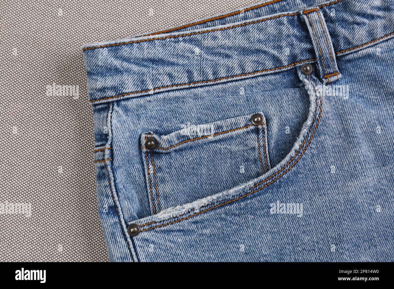 Eleganti jeans blu chiaro su tessuto grigio, primo piano della tasca interna Foto Stock