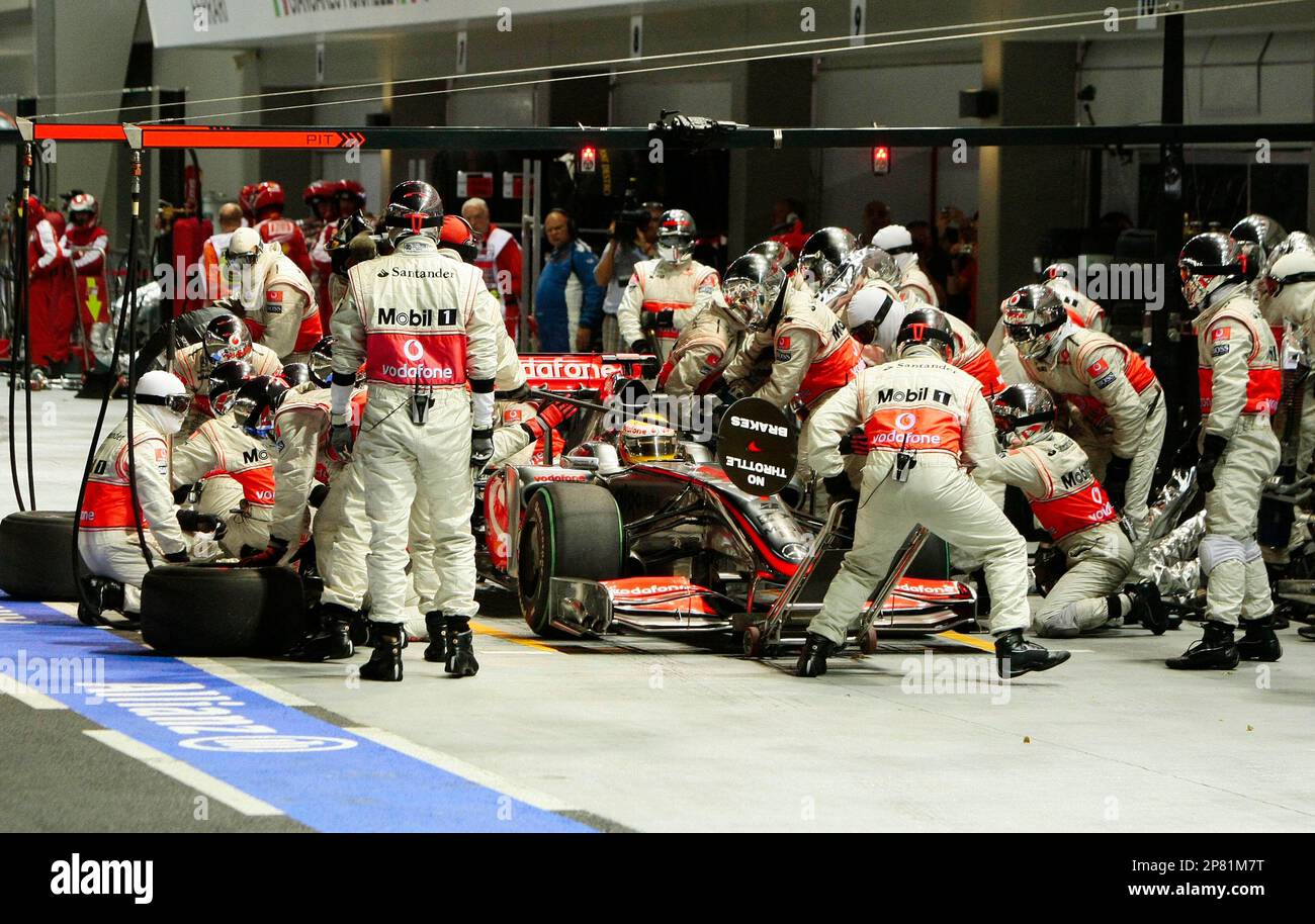 The McLaren Formula One mechanics refuel Britain's Lewis Hamilton's car during a pit stop at the