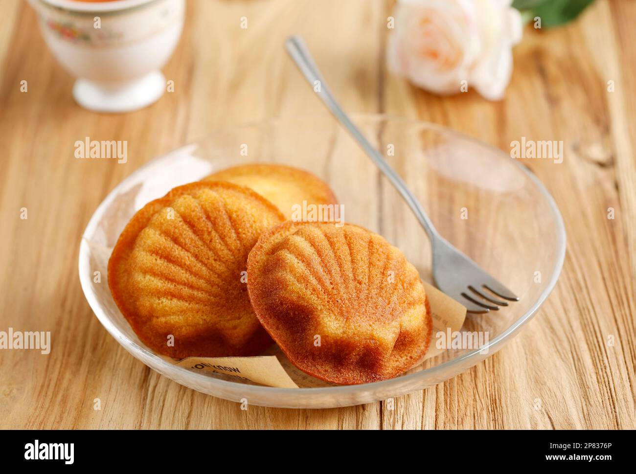 Biscotti francesi Madeleine Cake, Buttery e delicato, servito con tazza di tè, su sfondo di legno Foto Stock