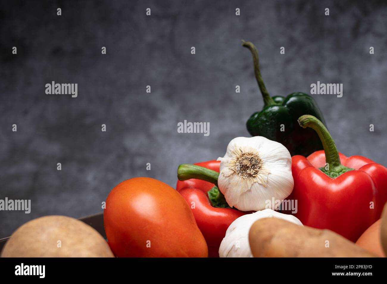 Un mucchio di ingredienti freschi e sani da fattoria a tavola, peperoni, pomodori, patate, cipolla, e aglio Foto Stock