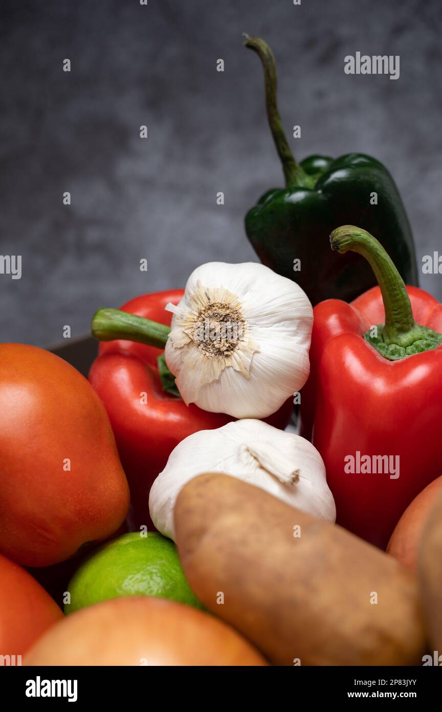Un mucchio di ingredienti freschi e sani da fattoria a tavola, peperoni, pomodori, patate, cipolla, e aglio Foto Stock