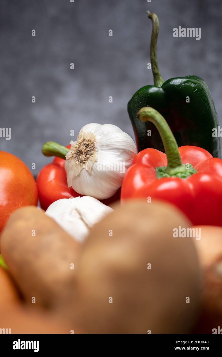 Un mucchio di ingredienti freschi e sani da fattoria a tavola, peperoni, pomodori, patate, cipolla, e aglio Foto Stock