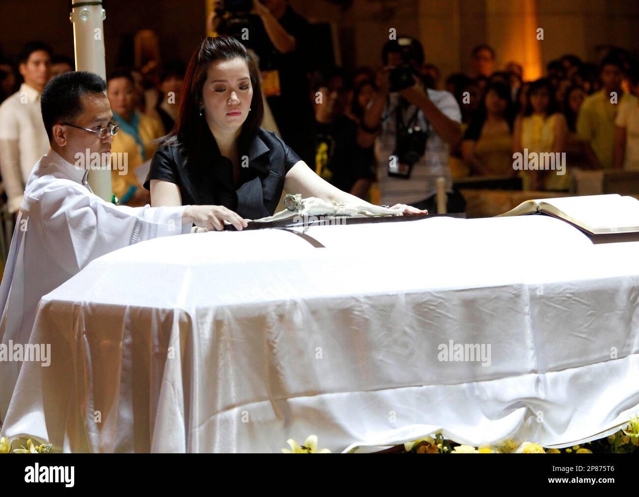 Kris Aquino, daughter of the late former Philippine President Corazon Aquino, places a cross on