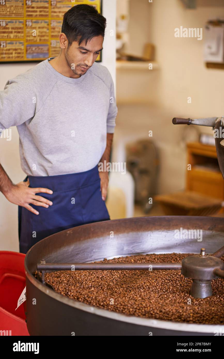 Tostatura lenta. una macchina per macinare e tostare i chicchi di caffè. Foto Stock