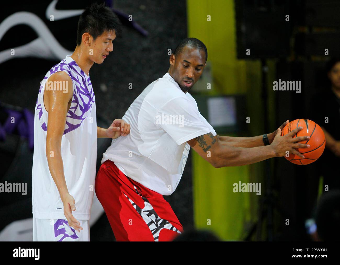 NBA superstar Kobe Bryant, right, of the Los Angeles Lakers coaches a local youth during a clinic Friday, July 24, 2009, in Hong Kong. The NBA Finals Most Valuable Player, is on the second leg of his Nike sponsored 2009 Asia tour which kicked off in the Philippines, to conduct basketball clinics with youth from the city-state before moving on to Shanghai and Chengdu, China. (AP Photo/Vincent Yu) Foto Stock