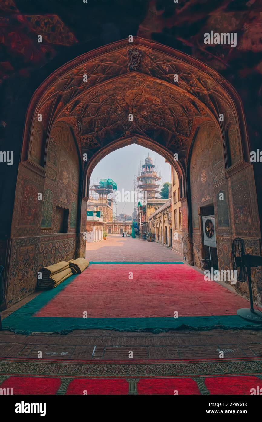 La nicchia ad arco all'ingresso della moschea che si affaccia sul Wazir Khan Chowk è riccamente decorata con statue di fiori e ha una delle orecchie di Lahore Foto Stock