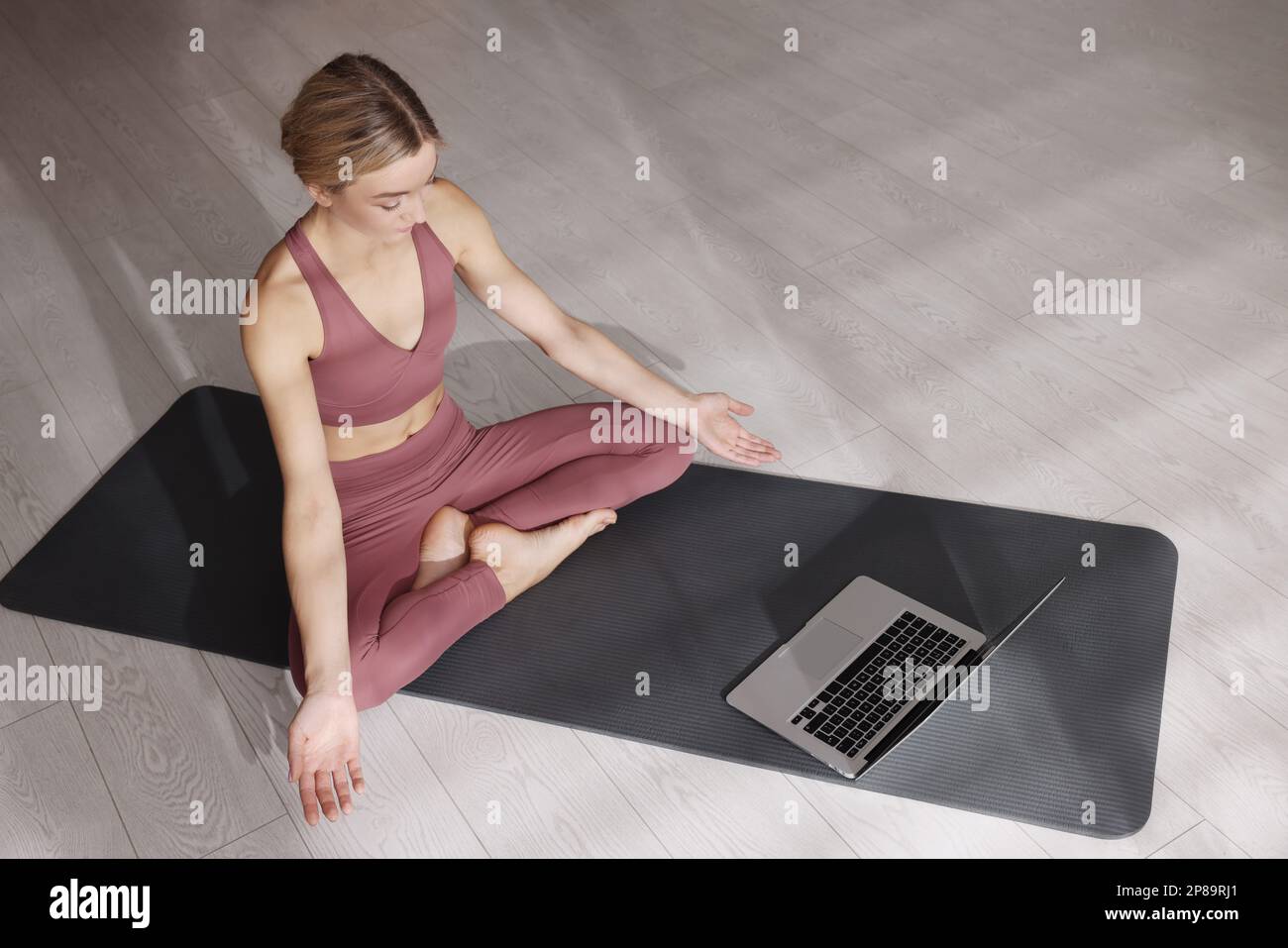 Bella donna che guarda on-line yoga classe a casa Foto Stock