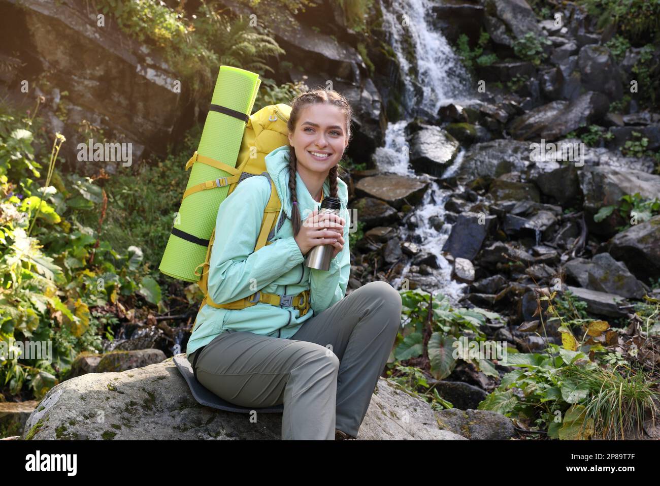 Tourist con pallone da vuoto vicino alla cascata in montagna Foto Stock