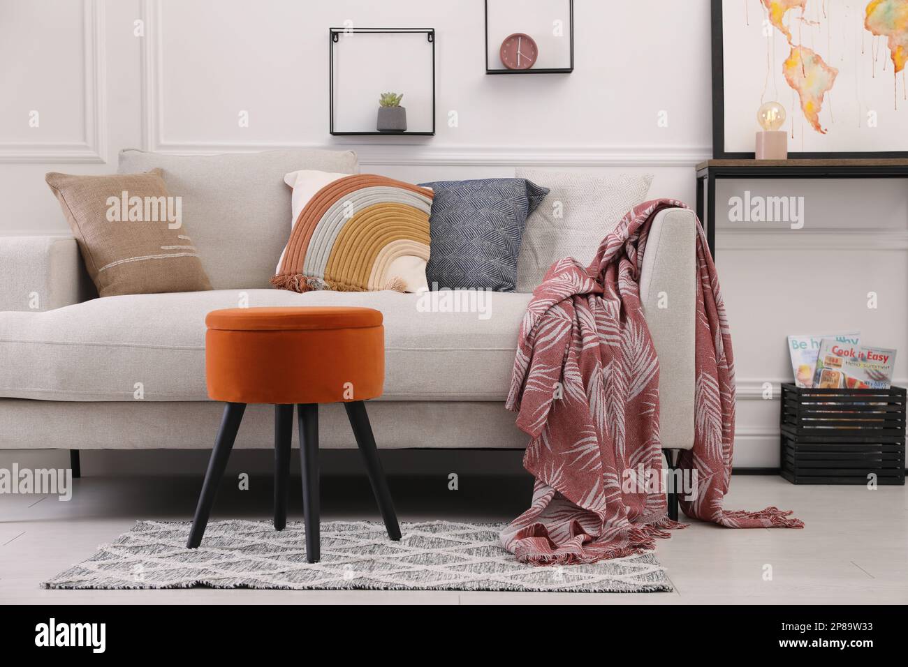 Elegante soggiorno interno con ottomana, divano e decorazioni Foto stock -  Alamy