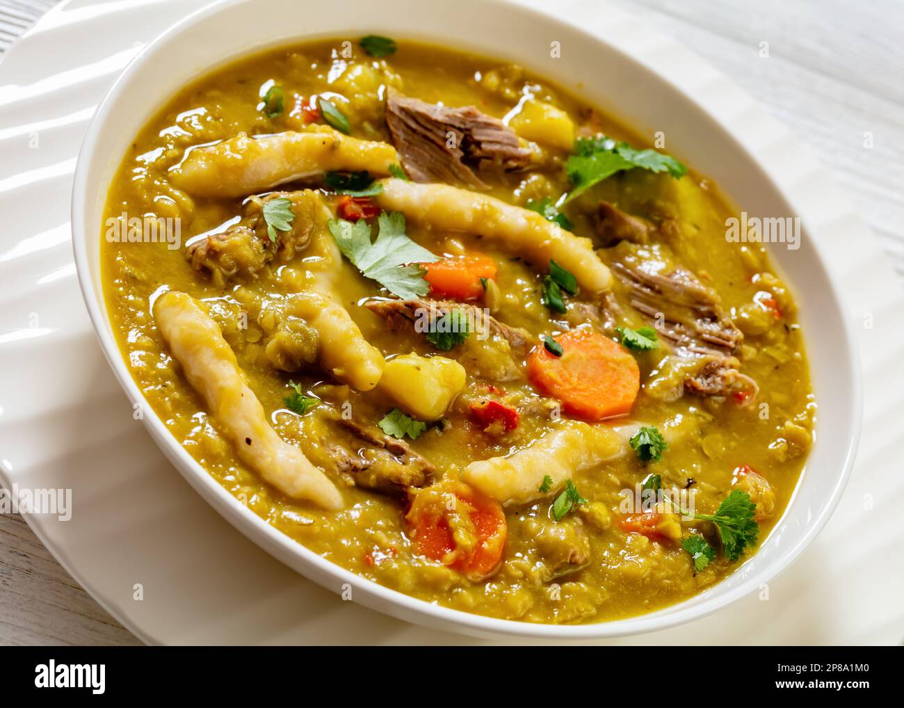 piselli da guno, zuppa di piselli con gnocchi, verdure e manzo in ciotola bianca Foto Stock