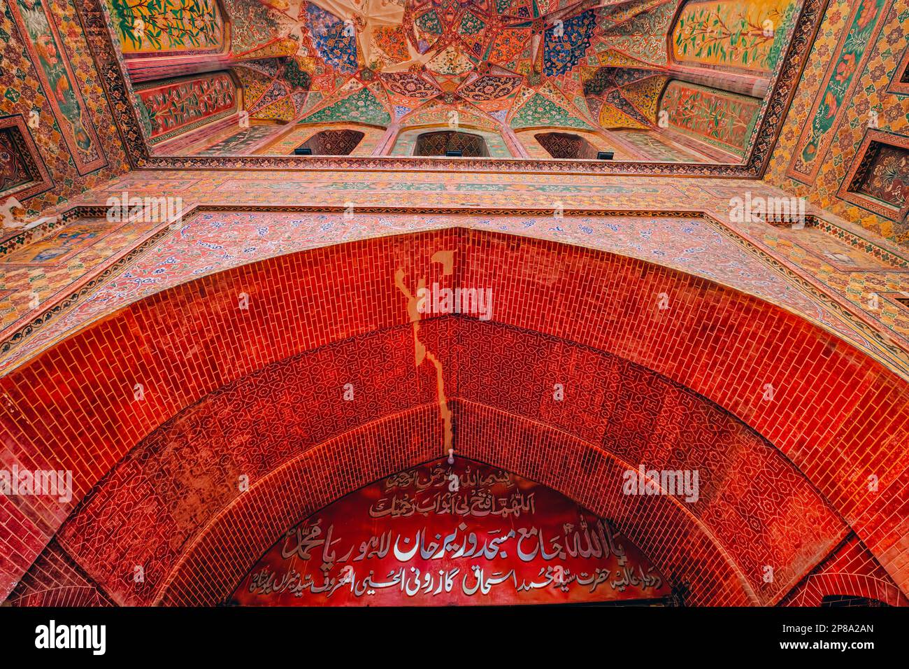 La nicchia ad arco all'ingresso della moschea che si affaccia sul Wazir Khan Chowk è riccamente decorata con statue di fiori e ha una delle orecchie di Lahore Foto Stock