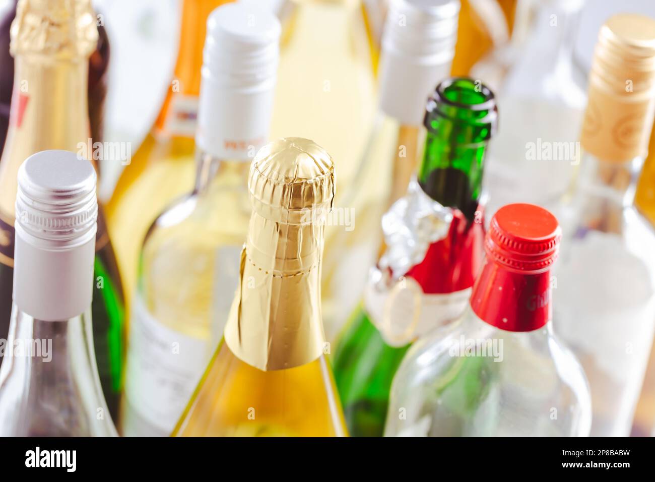 Bottiglie piene e vuote di diverse bevande alcoliche, abuso e dipendenza da alcol. Concetto di alcolismo. Foto Stock