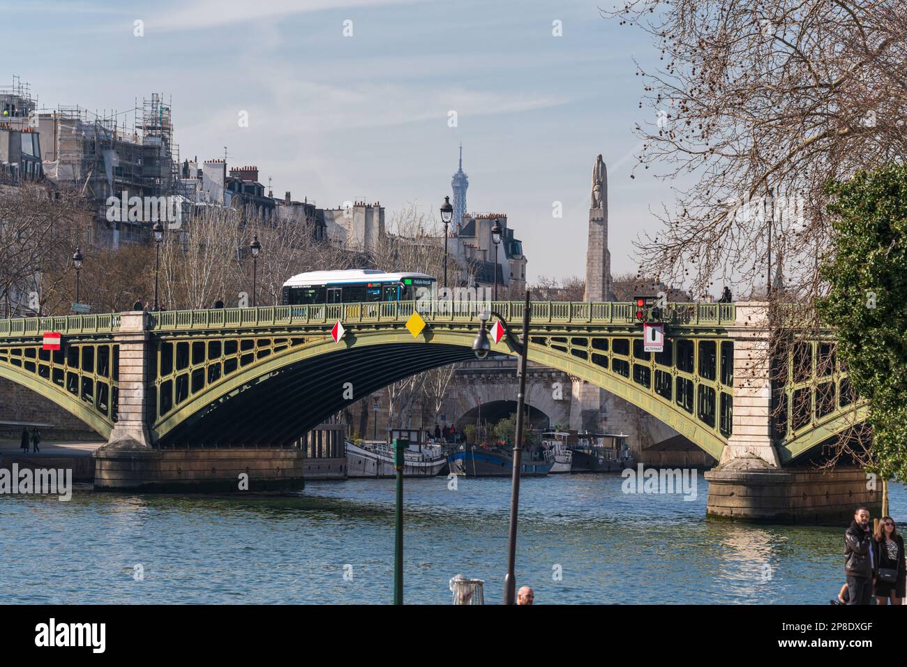 Un autobus elettrico passa sopra il Pont Sully Bridge a Parigi. Foto Stock