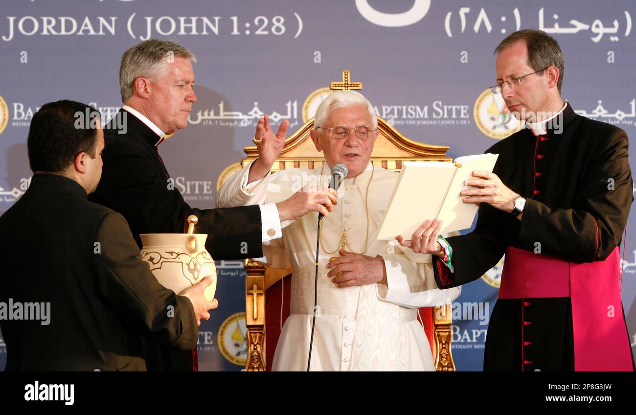 Monsignor William Millea, left, and Monsignor Guido Marini, right, assist  Pope Benedict XVI, centre as he blesses the first stones of the church of  the Latin and Greek-Melkiti during his visit to