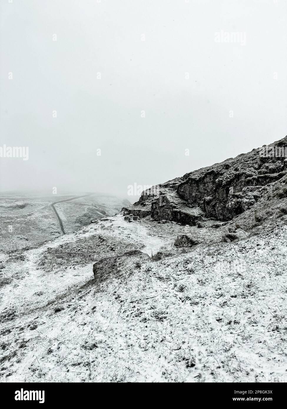 Montagne rocciose innevate sul Winnat's Pass in una giornata nuvolosa nel Peak District, Inghilterra Foto Stock