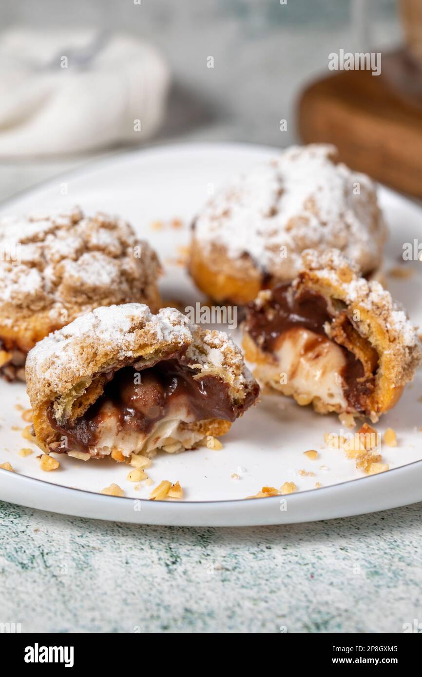 Soffi di crema appena sfornati. Torta Eclair con crema e ripieno di cioccolato. Primo piano Foto Stock