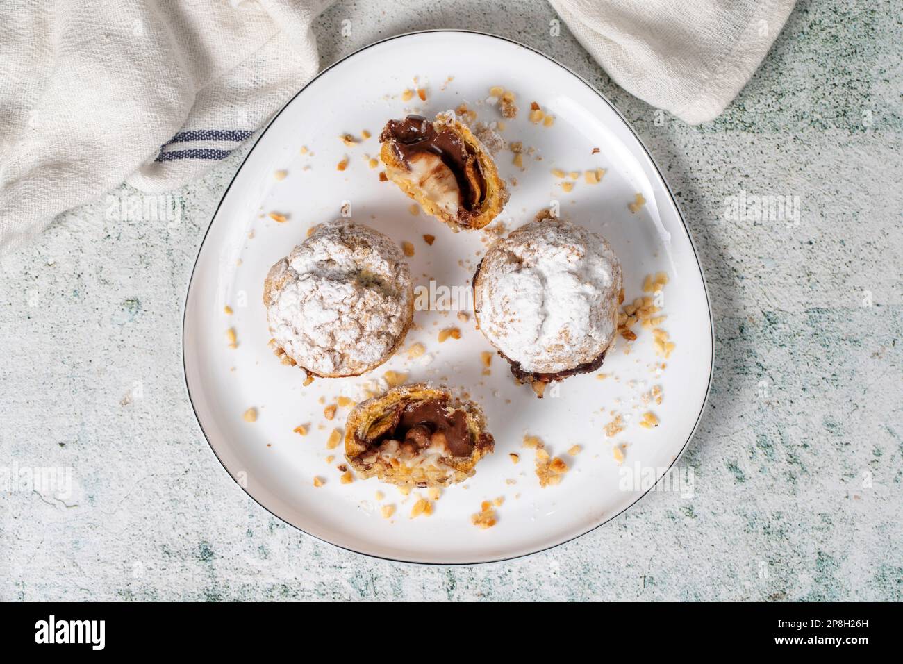 Soffi di crema appena sfornati. Torta Eclair con crema e ripieno di cioccolato. Vista dall'alto Foto Stock