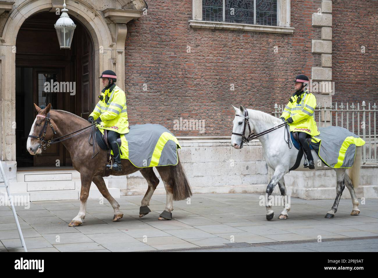 Gli agenti di polizia della città di Londra cavalcano cavalli attraverso il Bow Churchyard di fronte alla chiesa di St Mary-le-Bow. Londra, Inghilterra, Regno Unito Foto Stock