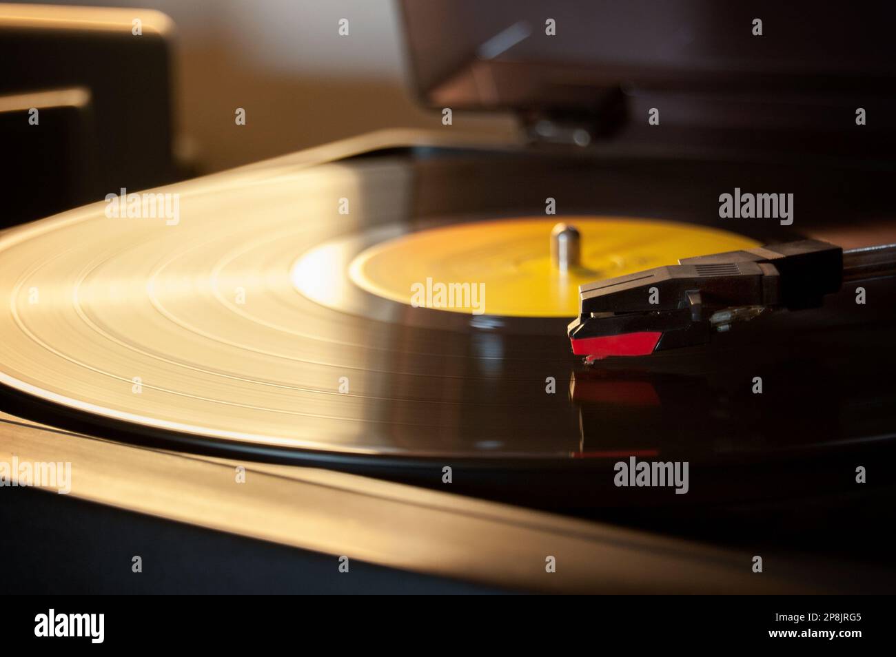 Un giradischi riproduce un disco in vinile con uno sfondo sfocato Foto Stock