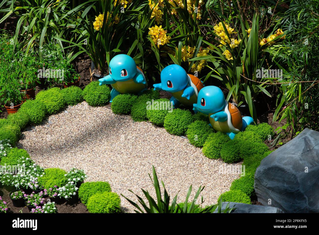 I personaggi della statuetta Pokemon squirtle stanno posando con piante verdi. Flower Dome presso Gardens by the Bay, Singapore. Foto Stock