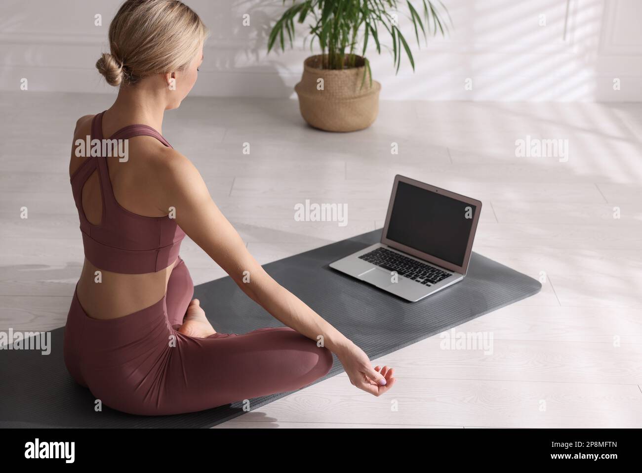 Donna che guarda classe di yoga online a casa Foto Stock