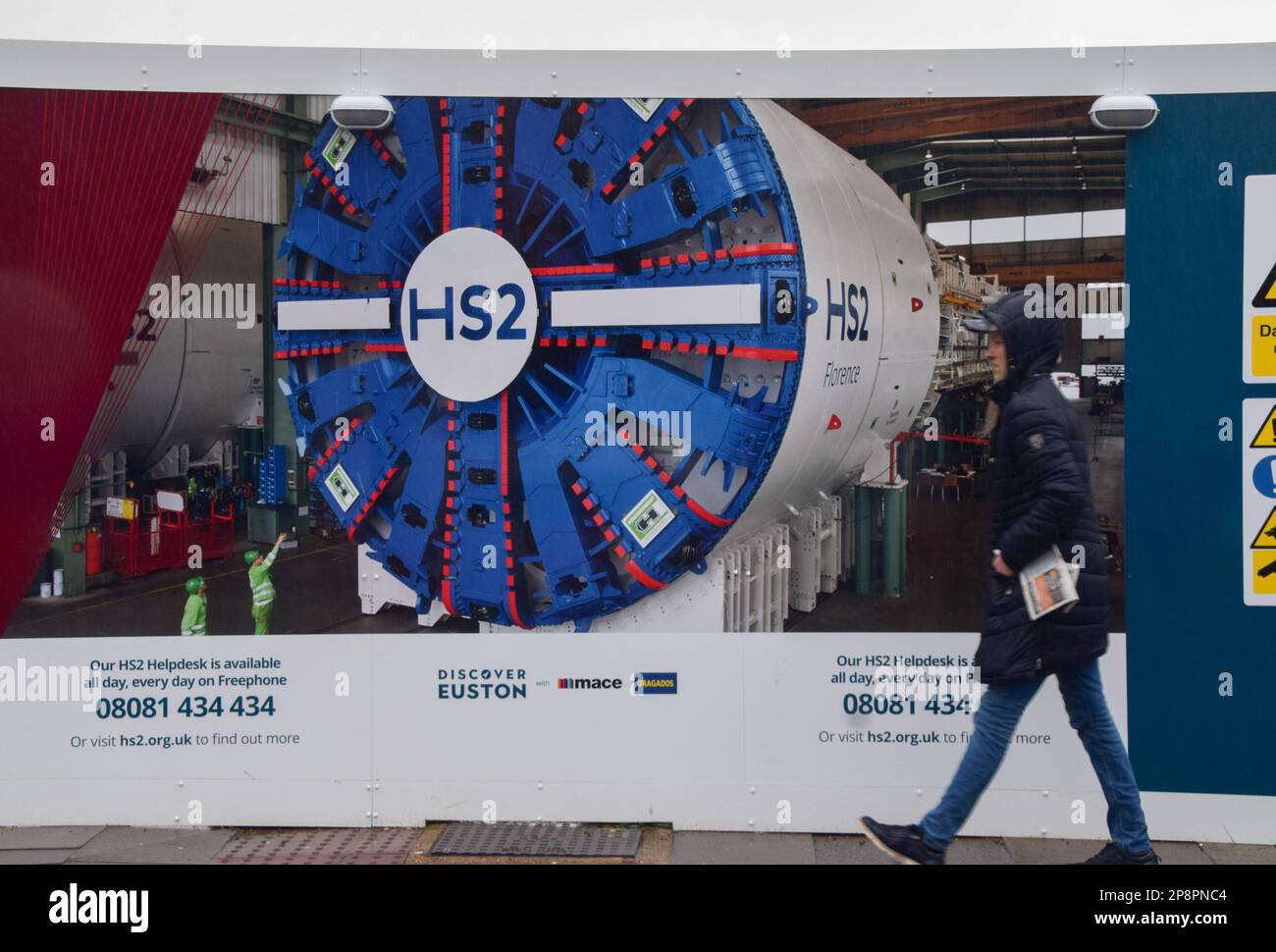 Londra, Inghilterra, Regno Unito. 9th Mar, 2023. Un pedone passa davanti a un cartello presso il cantiere HS2 vicino alla stazione di Euston. Parti del controverso progetto ferroviario del HS2 70 100 (alta velocità 2) sono destinati a subire ritardi, poiché le stime dei costi sono salite a un valore compreso tra Â miliardi di sterline e Â miliardi di sterline. (Credit Image: © Vuk Valcic/ZUMA Press Wire) SOLO PER USO EDITORIALE! Non per USO commerciale! Foto Stock