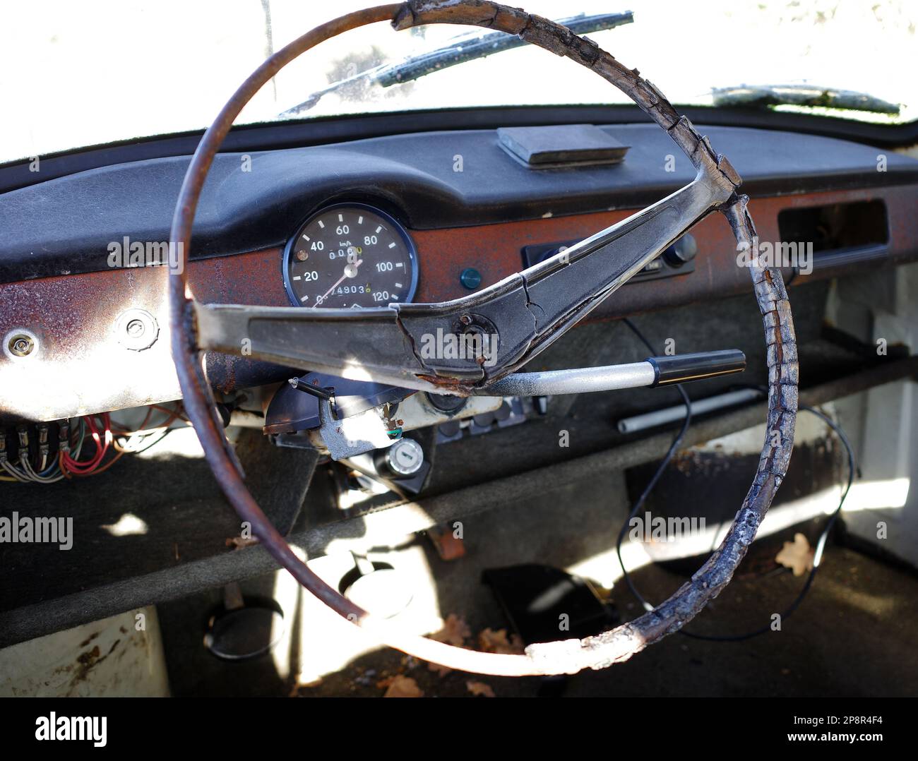 Cruscotto di una vettura distrutta con volante deformato, blocco accensione e tachimetro Foto Stock