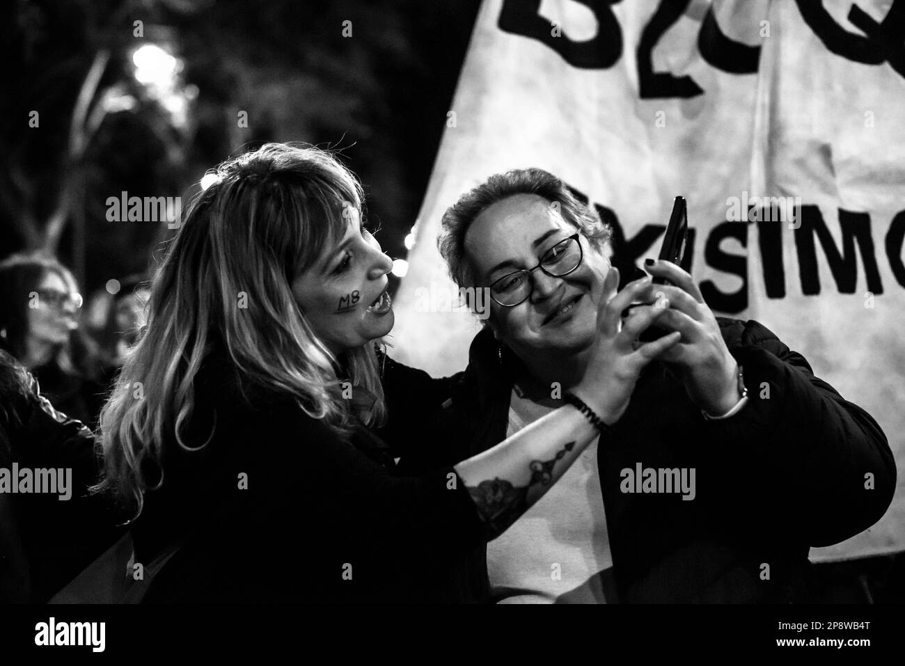 Due donne che guardano un telefono cellulare. Le donne, e i sostenitori, a Madrid hanno dimostrato in città durante la Giornata internazionale della donna del 8M che ha riempito il cen Foto Stock