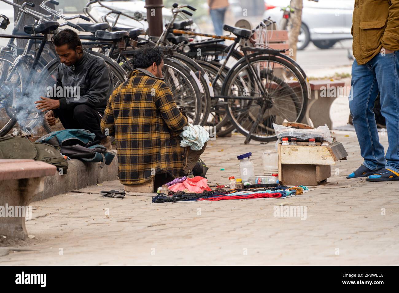 strada lato cobbler seduta su strada e rammendare scarpe nei mesi invernali nel settore 17 chandigarh durante la mattina mostrando come i poveri guadagnano da vivere Foto Stock