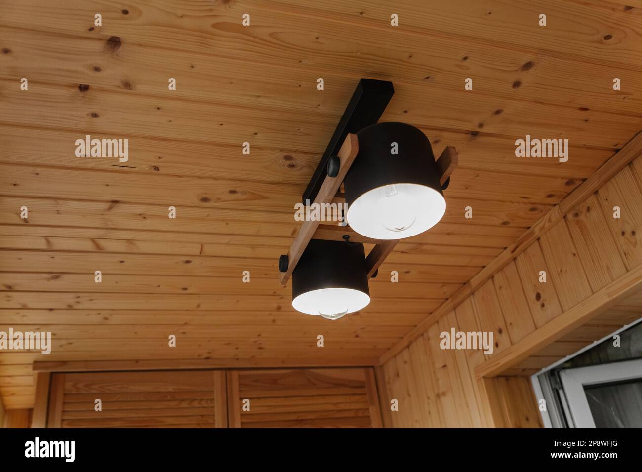 Dettagli interni, soffitto. Elegante composizione scandinava di reggiseno nero e pareti in legno. Stile loft con arredamento moderno. Foto Stock