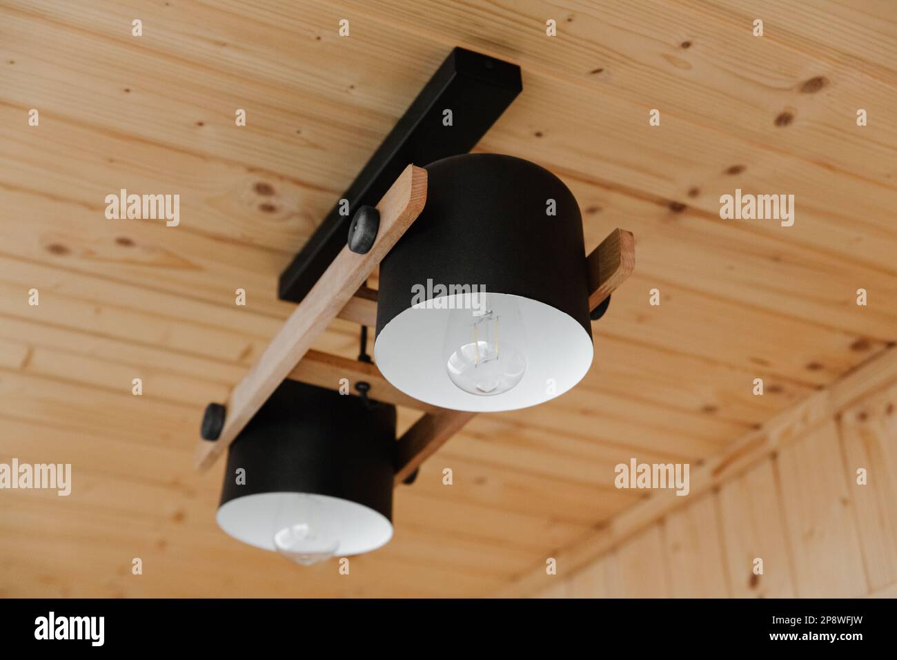 Dettagli interni, soffitto. Elegante composizione scandinava di reggiseno nero e pareti in legno. Stile loft con arredamento moderno. Foto Stock