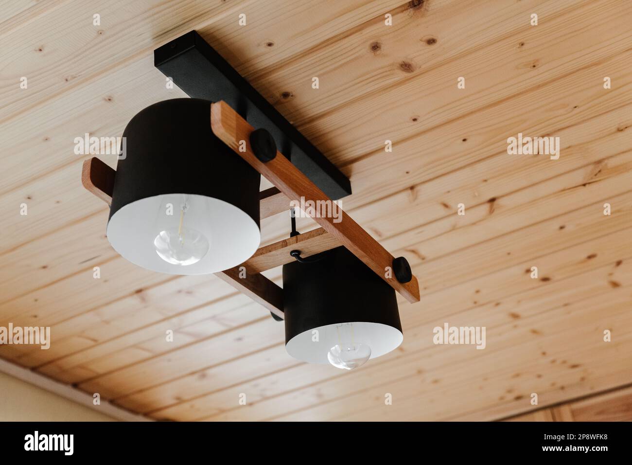 Dettagli interni, soffitto. Elegante composizione scandinava di reggiseno nero e pareti in legno. Stile loft con arredamento moderno. Foto Stock
