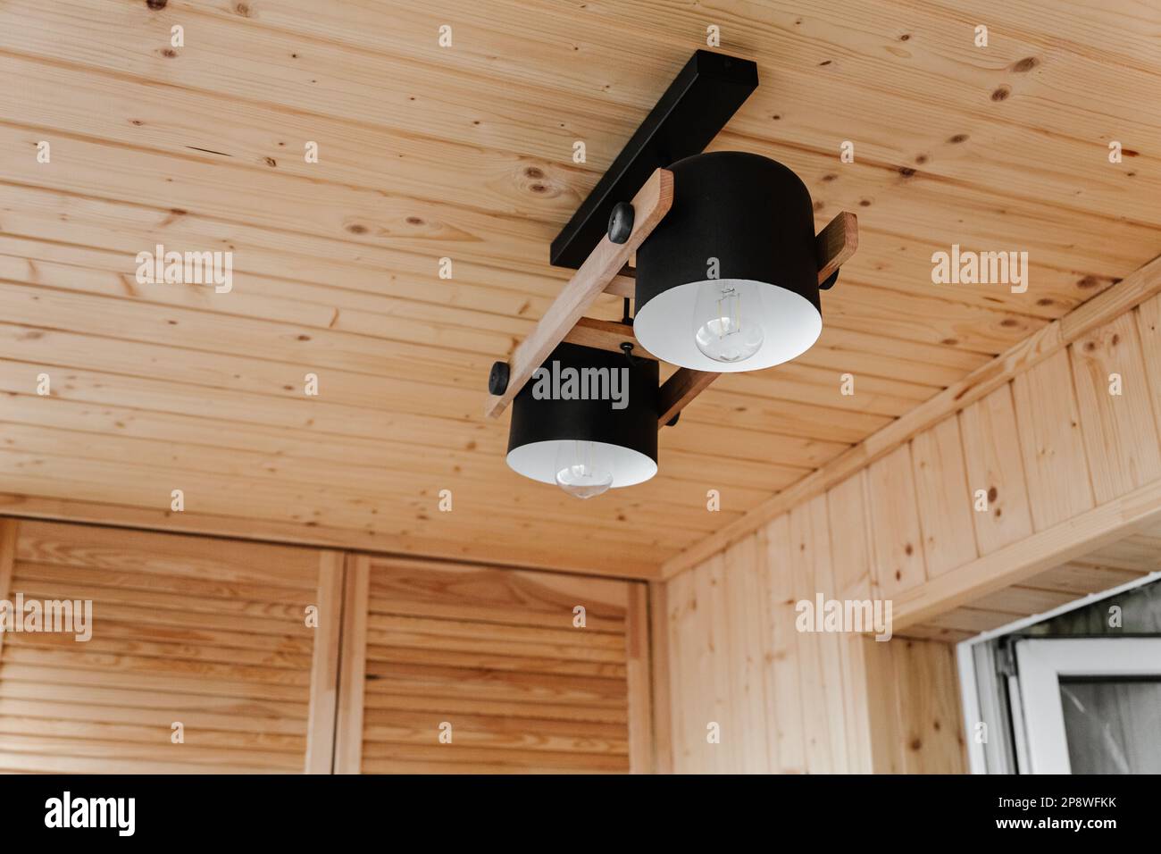 Dettagli interni, soffitto. Elegante composizione scandinava di reggiseno nero e pareti in legno. Stile loft con arredamento moderno. Foto Stock