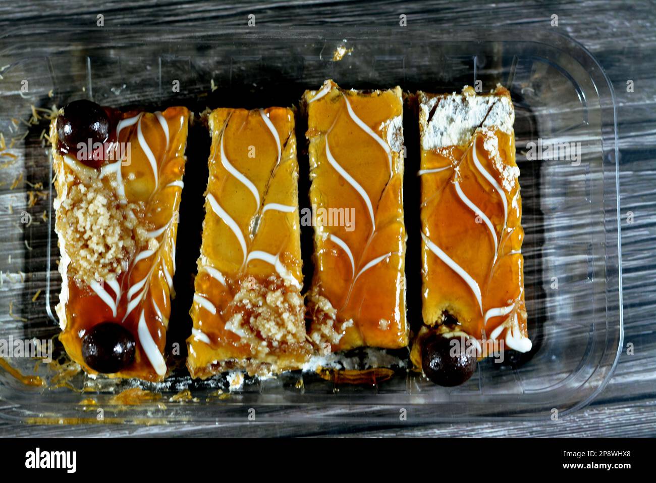 Dessert egiziano a strati di semola di basbousa, kunafa knafeh, panna montata, salsa al caramello insieme imbevuta di dolce e cosparsa di noci, Foto Stock