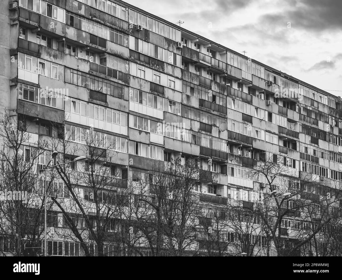 Edificio di appartamenti logoro dell'epoca comunista contro il cielo blu a Bucarest Romania. Un brutto complesso abitativo comunista tradizionale Foto Stock