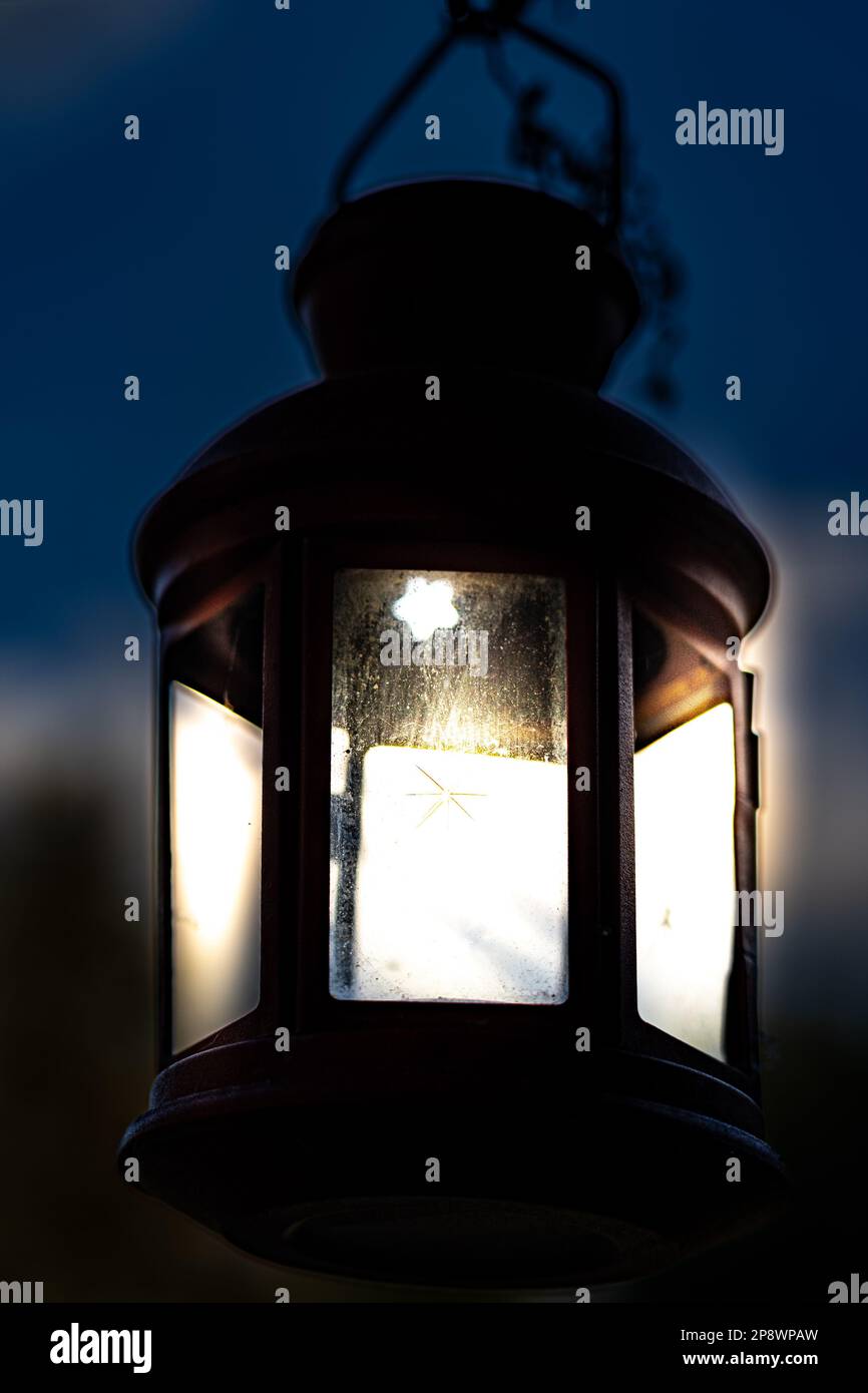 Lanterna con vetro e sfondo sfocato con luci accese di notte Foto Stock