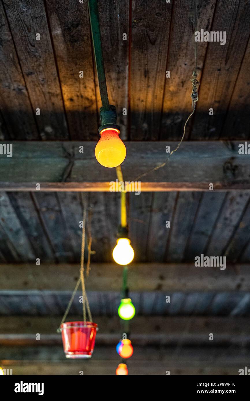 Luci colorate delle lampade sul tetto in legno fuori casa Foto Stock