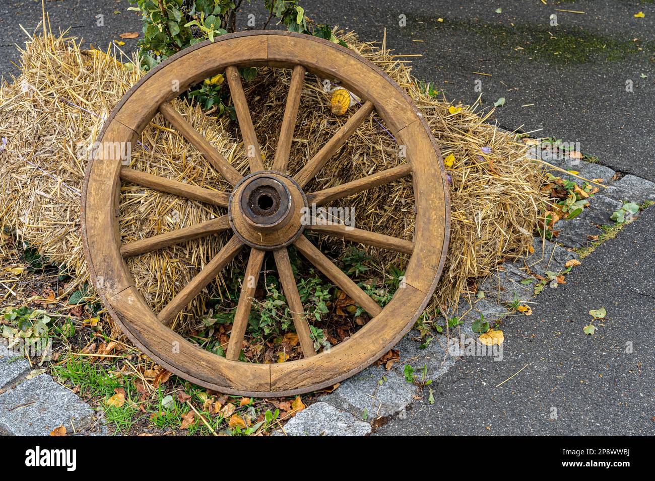 Ruota di legno e paglia come decorazione sul terreno Foto Stock