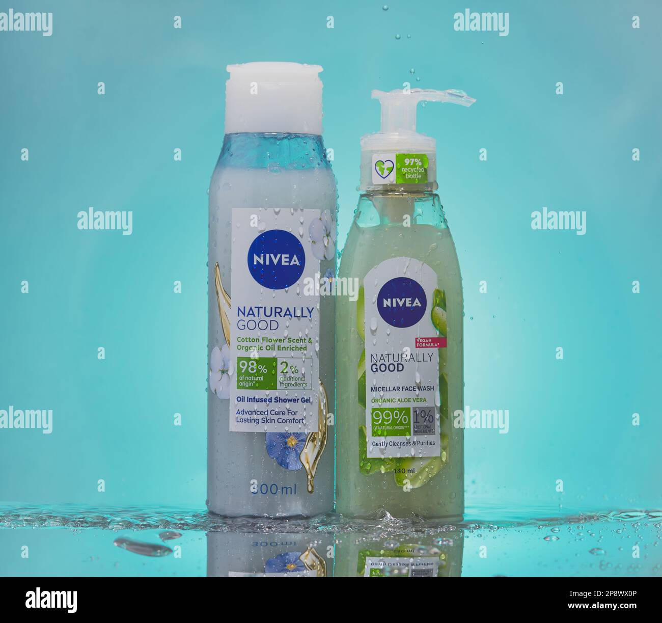 Gel doccia NIVEA e lavaviso, affiancati su una superficie riflettente con sfondo blu sfumato. Foto Stock