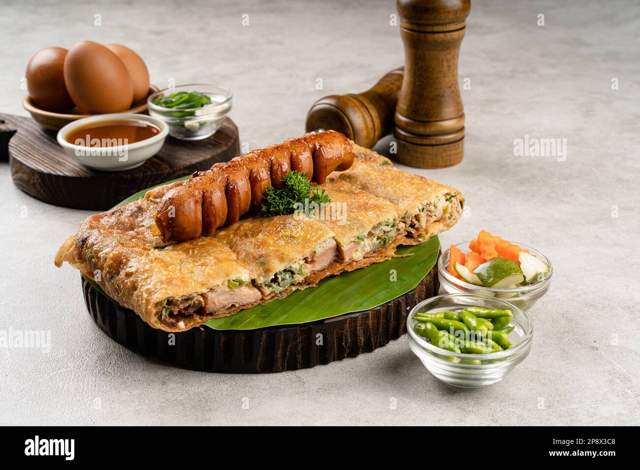 Martabak telur è cibo di strada indonesiano, fatto con saporita pasta fritta in padella farcita con uova, cipollina, carne, salsiccia, spezie e formaggio. Foto Stock