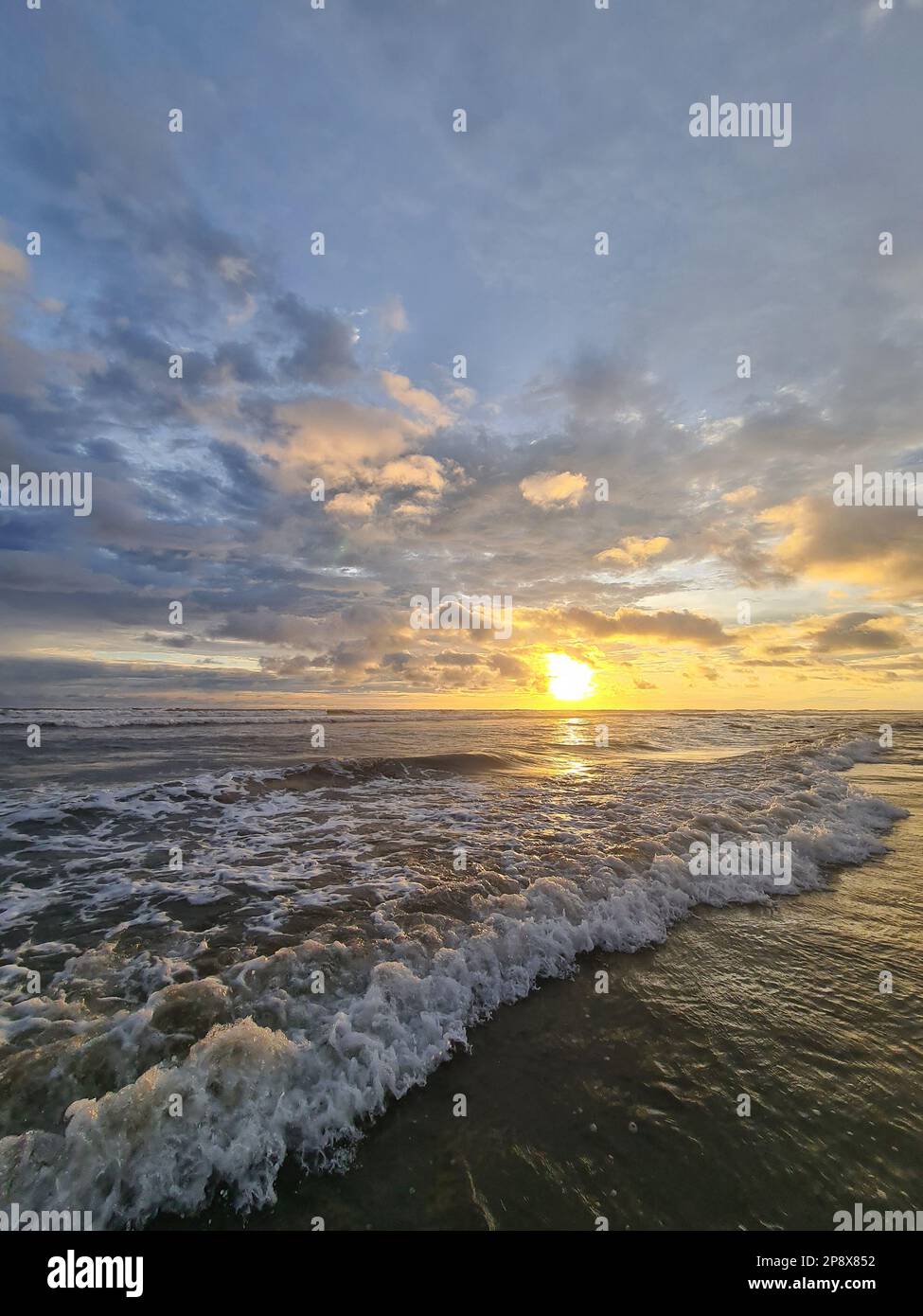 Piccola onda dell'oceano sul tramonto spettacolare sfondo del cielo Foto Stock