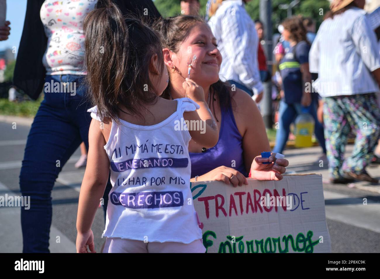 Buenos Aires, Argentina; 8 marzo 2023: Sciopero femminista internazionale. Il toddler fa una donna con i glitter, sul retro della sua camicia ci è un mess Foto Stock