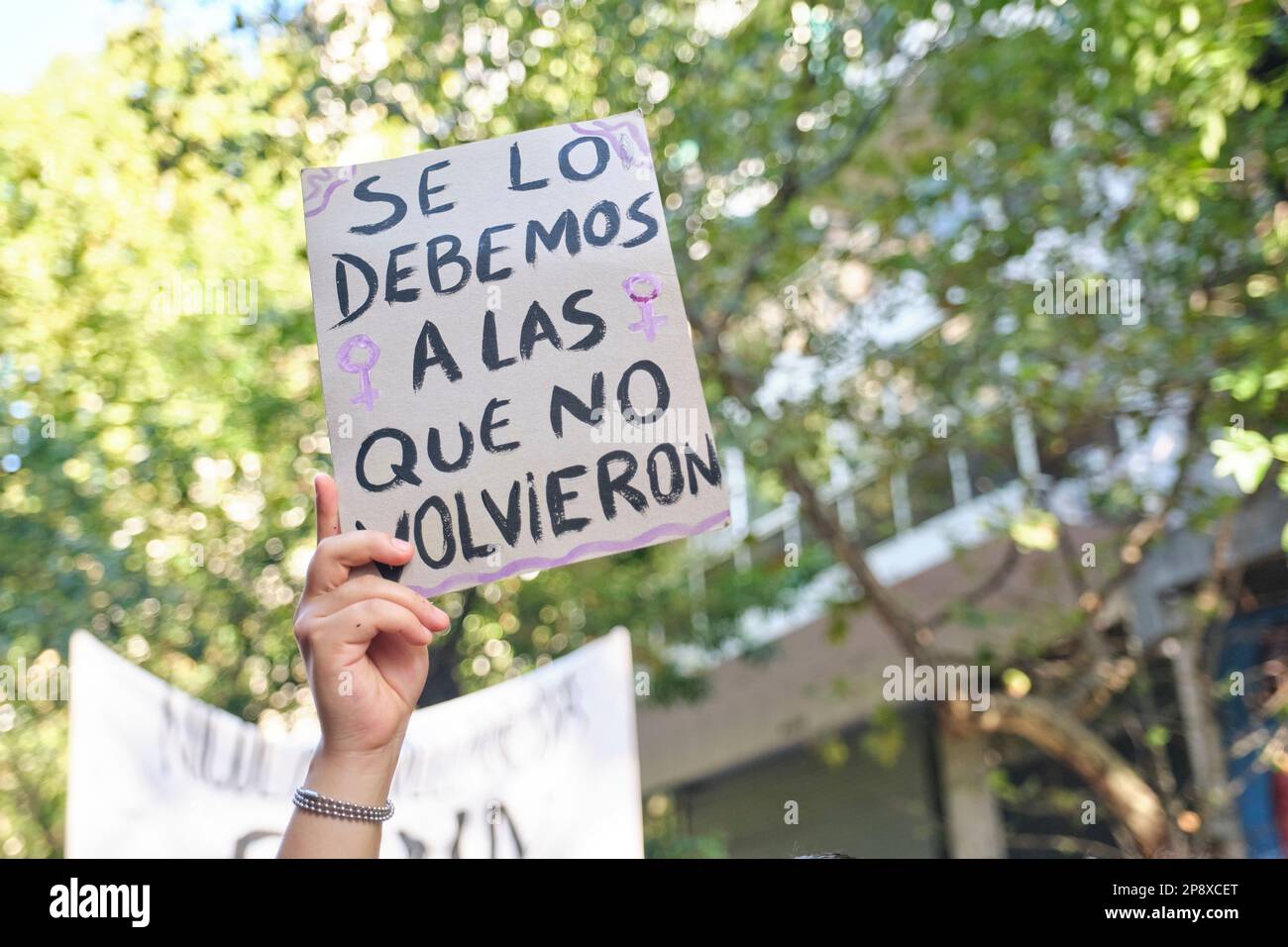 Buenos Aires, Argentina; 8 marzo 2023: Sciopero femminista internazionale, una donna irriconoscibile tiene un segno con il testo lo dobbiamo a coloro che di Foto Stock