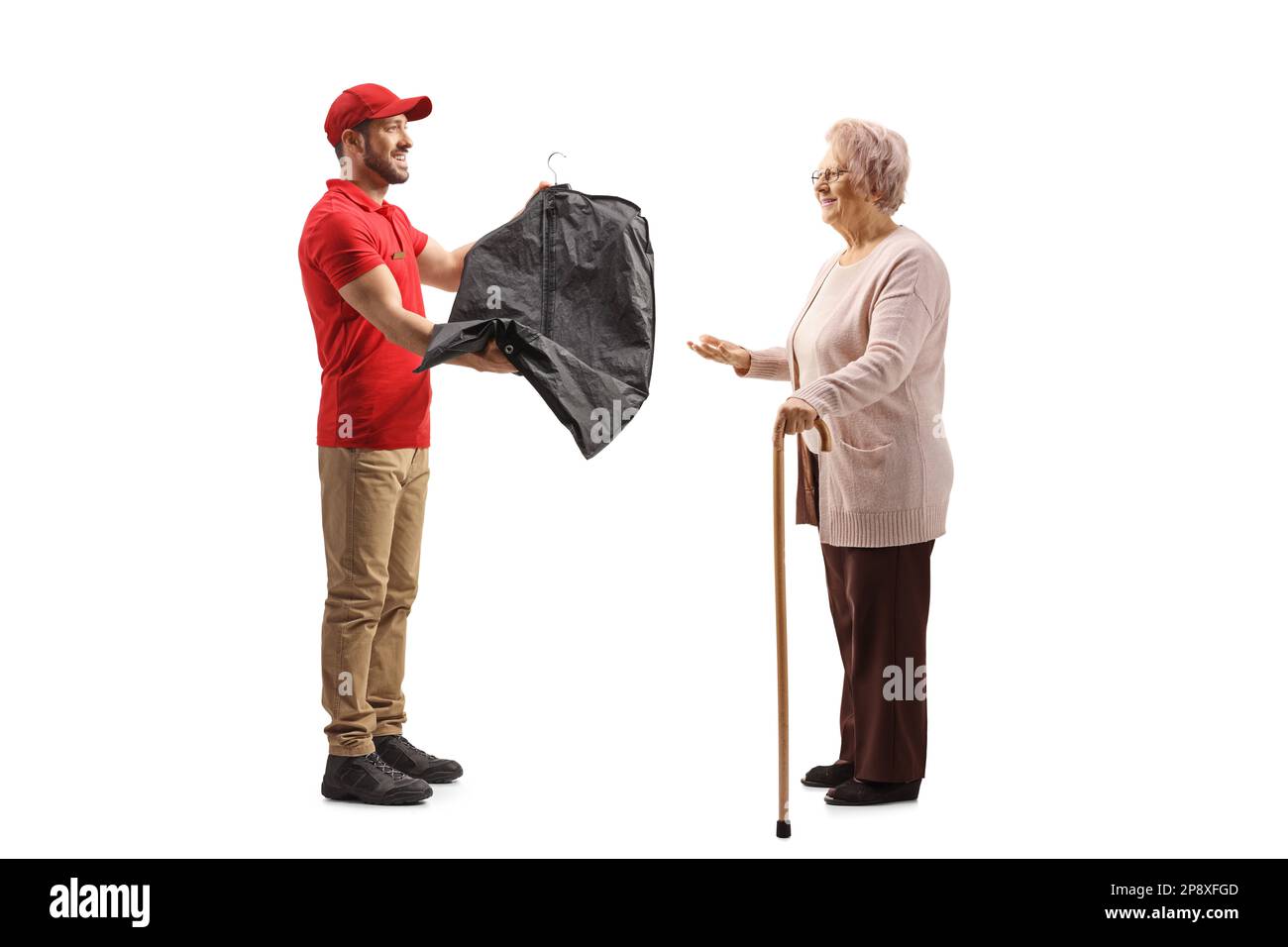 Il lavoratore consegna i vestiti di pulitura a secco ad una signora anziana isolata su uno sfondo bianco Foto Stock