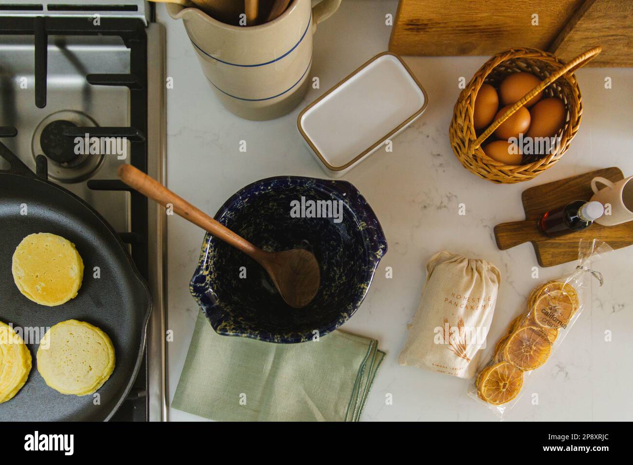 Un'immagine sopraelevata dei pancake che vengono preparati e degli ingredienti sul bancone della cucina Foto Stock
