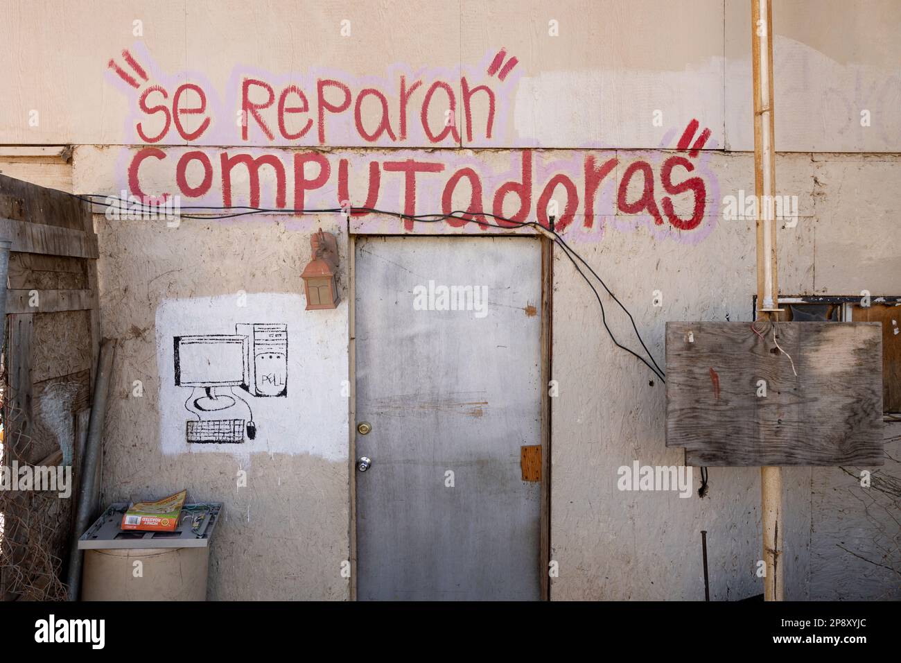 Ensenada, Baja California, Messico - segno di riparazione computer dipinto su una parete di una casa in un quartiere più povero Foto Stock