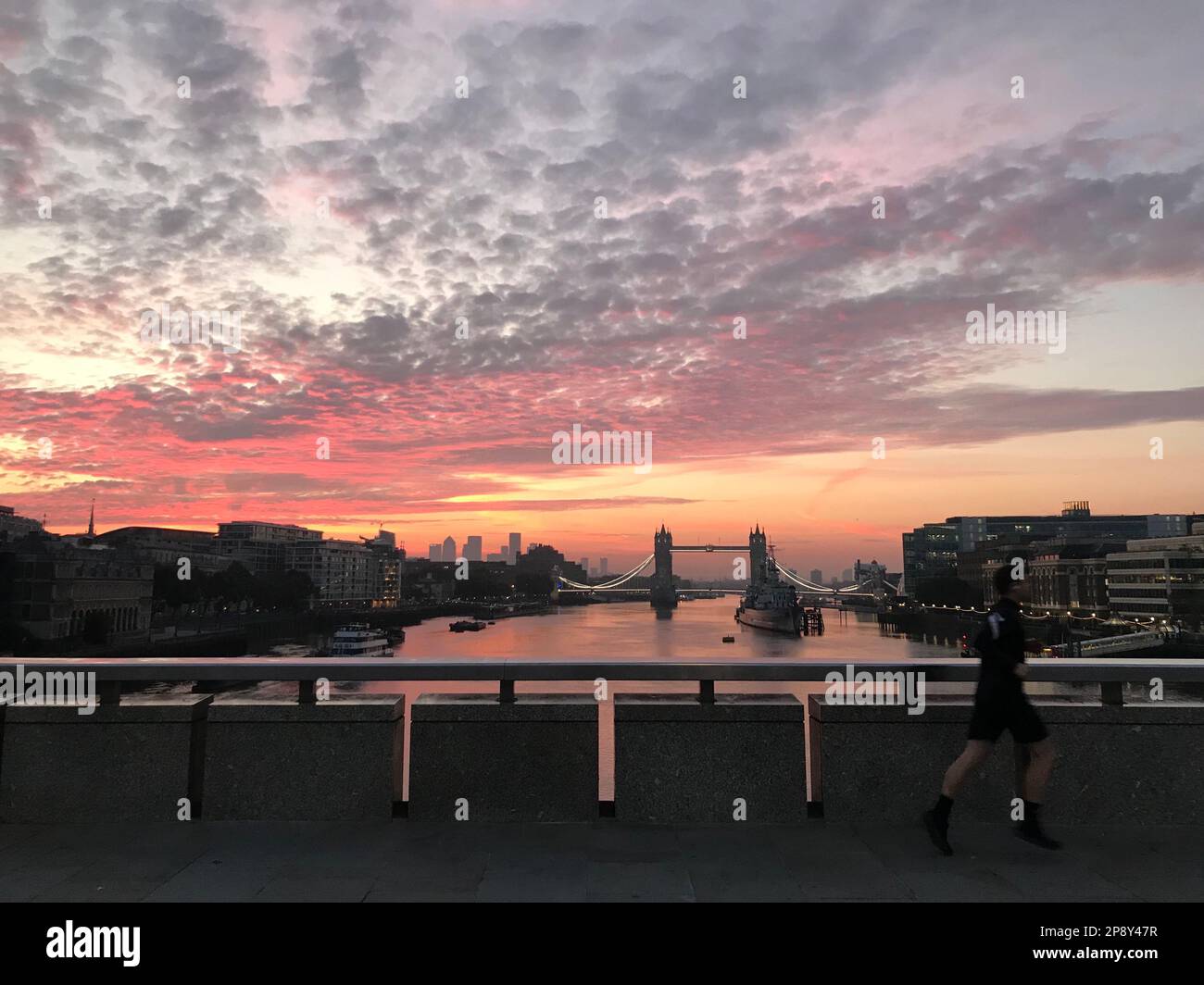 Bellissima alba di prima mattina sul Tamigi con un pareggiatore sfocato sul London Bridge e sul Tower Bridge sullo sfondo, Londra, Regno Unito Foto Stock