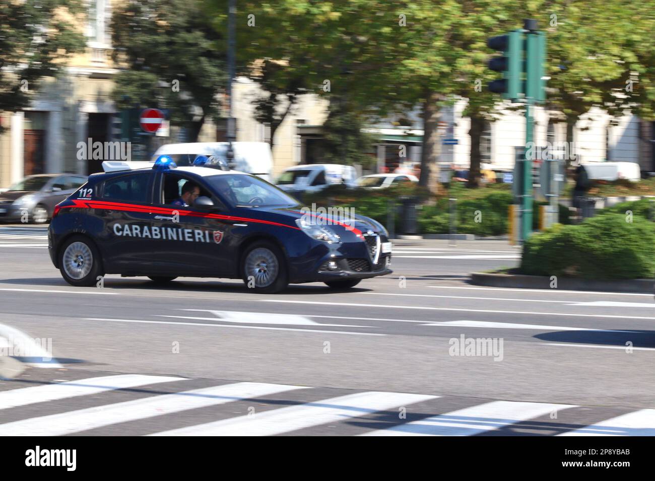 I carabinieri rispondono ad una chiamata di emergenza nella loro Alfa Romeo Giulietta a velocità di guida attraverso le strade del porto italiano di Trieste. Foto Stock