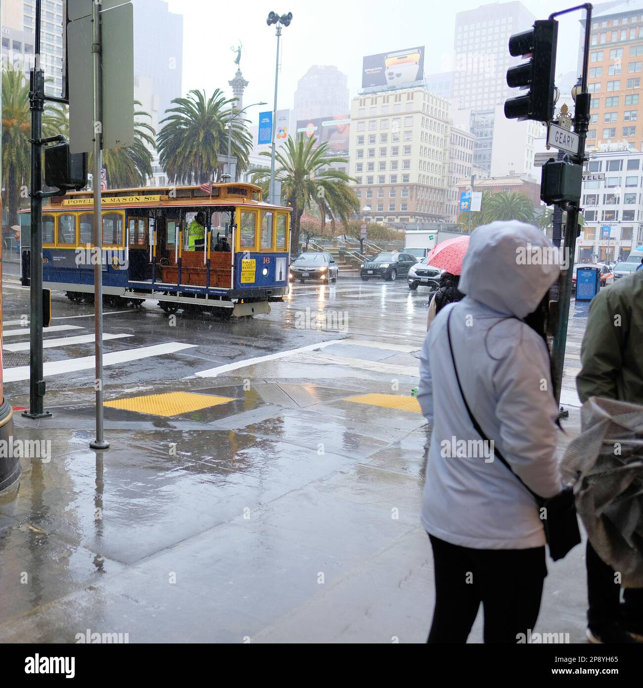 Turisti e visitatori su un tram sotto la pioggia nel centro di San Francisco, California; persone in condizioni di pioggia e clima umido. Foto Stock